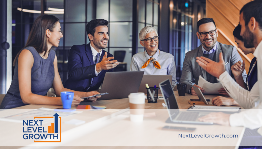 A group of six professionals sit around a conference table, engaged in discussion with laptops and notebooks, highlighting strong company culture next to a Next Level Growth logo and website address.
