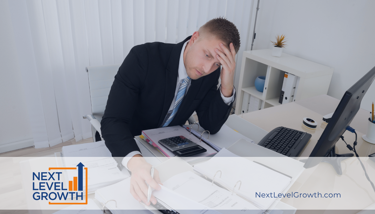 A man in a suit sits at a desk, looking exhausted while reviewing documents and using a calculator. The text reads “NEXT LEVEL GROWTH” and “NextLevelGrowth.com.”.