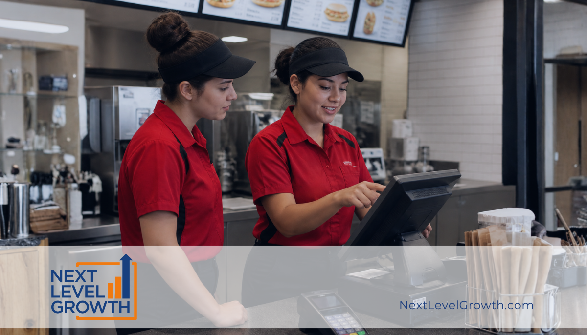 Two fast food restaurant workers in red uniforms stand at a counter, one pointing at the touchscreen register with clear commitment to excellent service and seamless execution. A “Next Level Growth” logo and website appear at the bottom of the image.